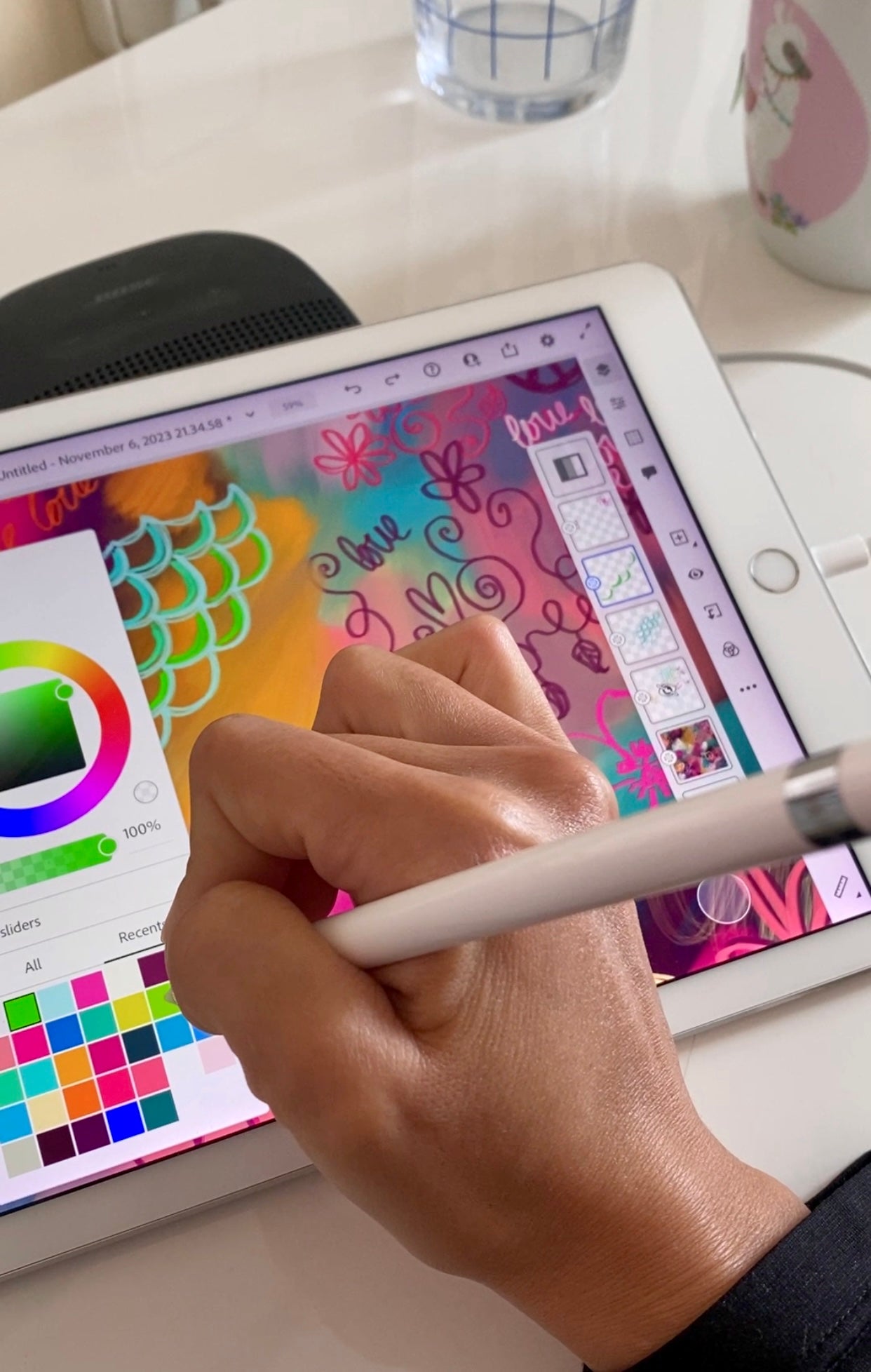 Hand drawing with a stylus on a digital drawing app on a tablet with a colorful screen.