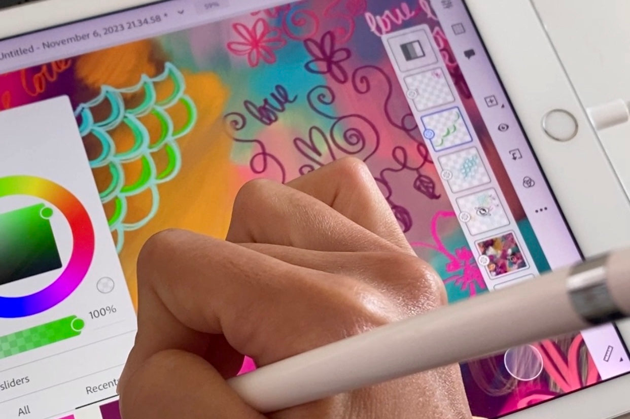 Hand drawing with a stylus on a digital art application with colorful designs on a tablet screen.