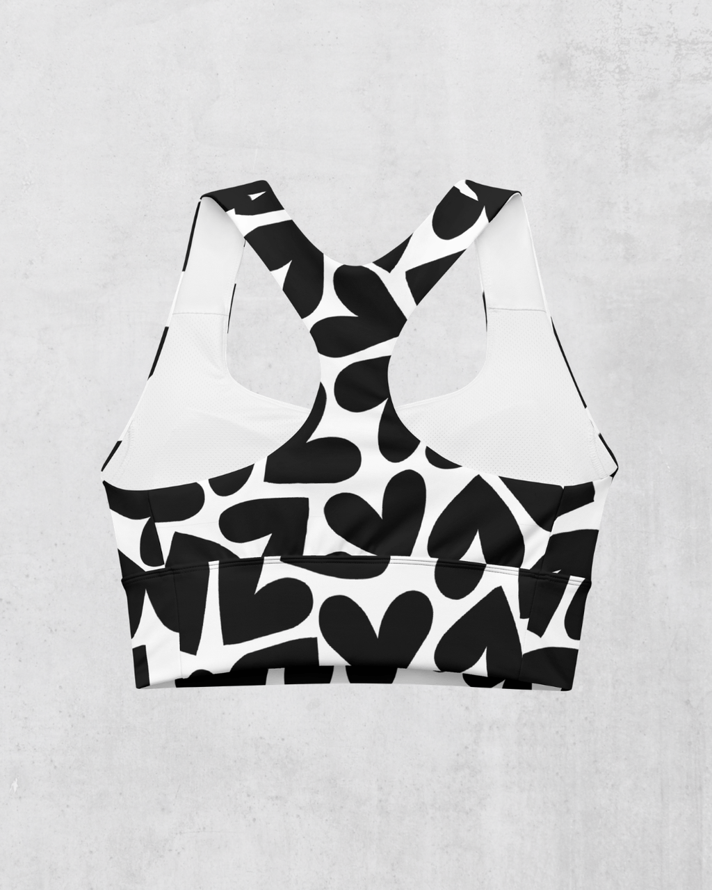 Black and white heart patterned sports bra on a light gray background, ack side