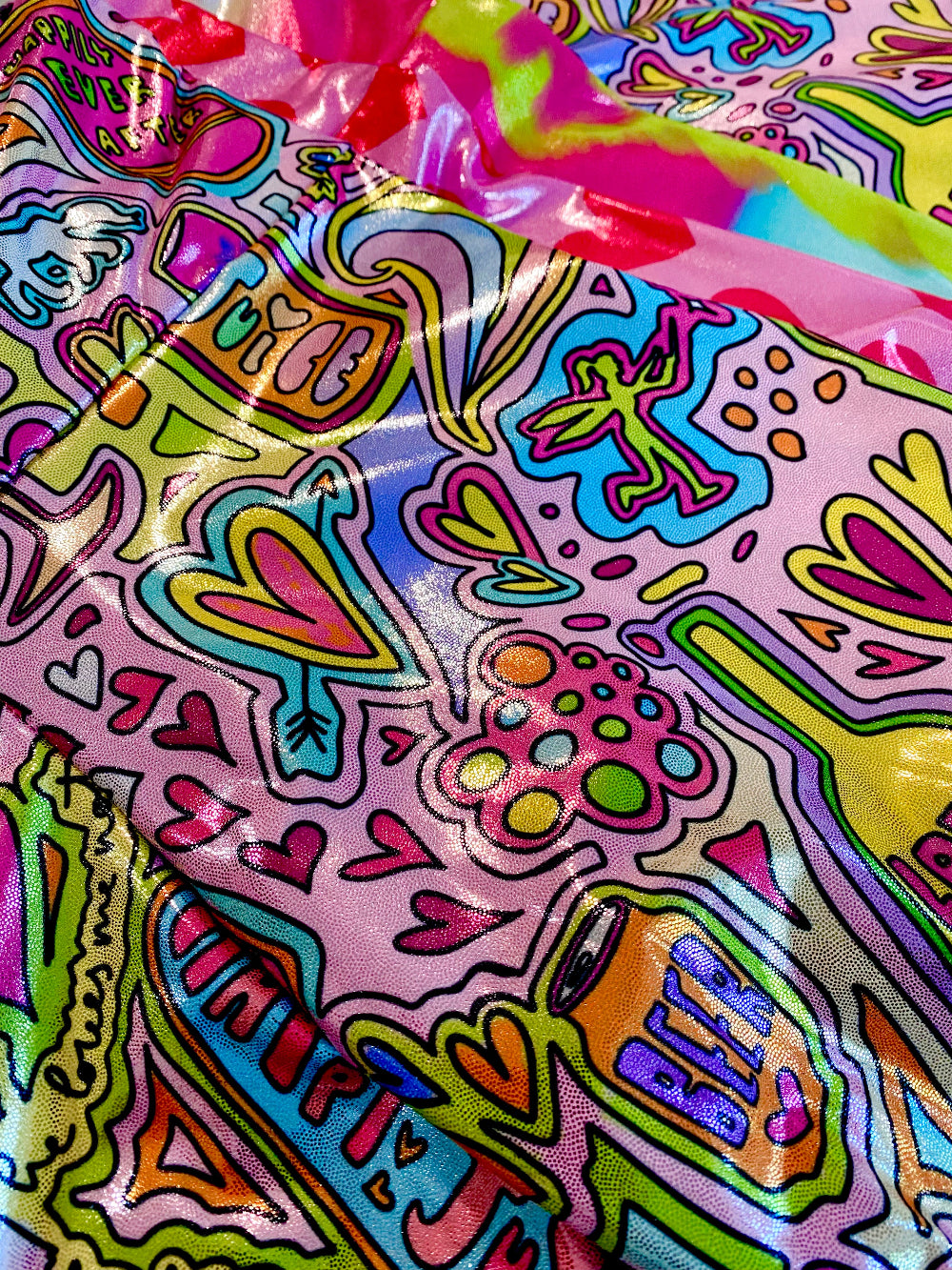 Colorful glitter shorts fabric closeup with whimsical fairytale doodles