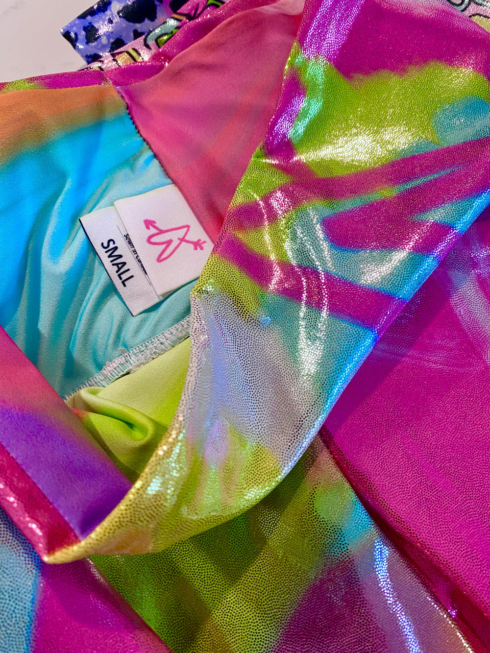 Colorful glitter shorts fabric close up showing the inside of the waist band