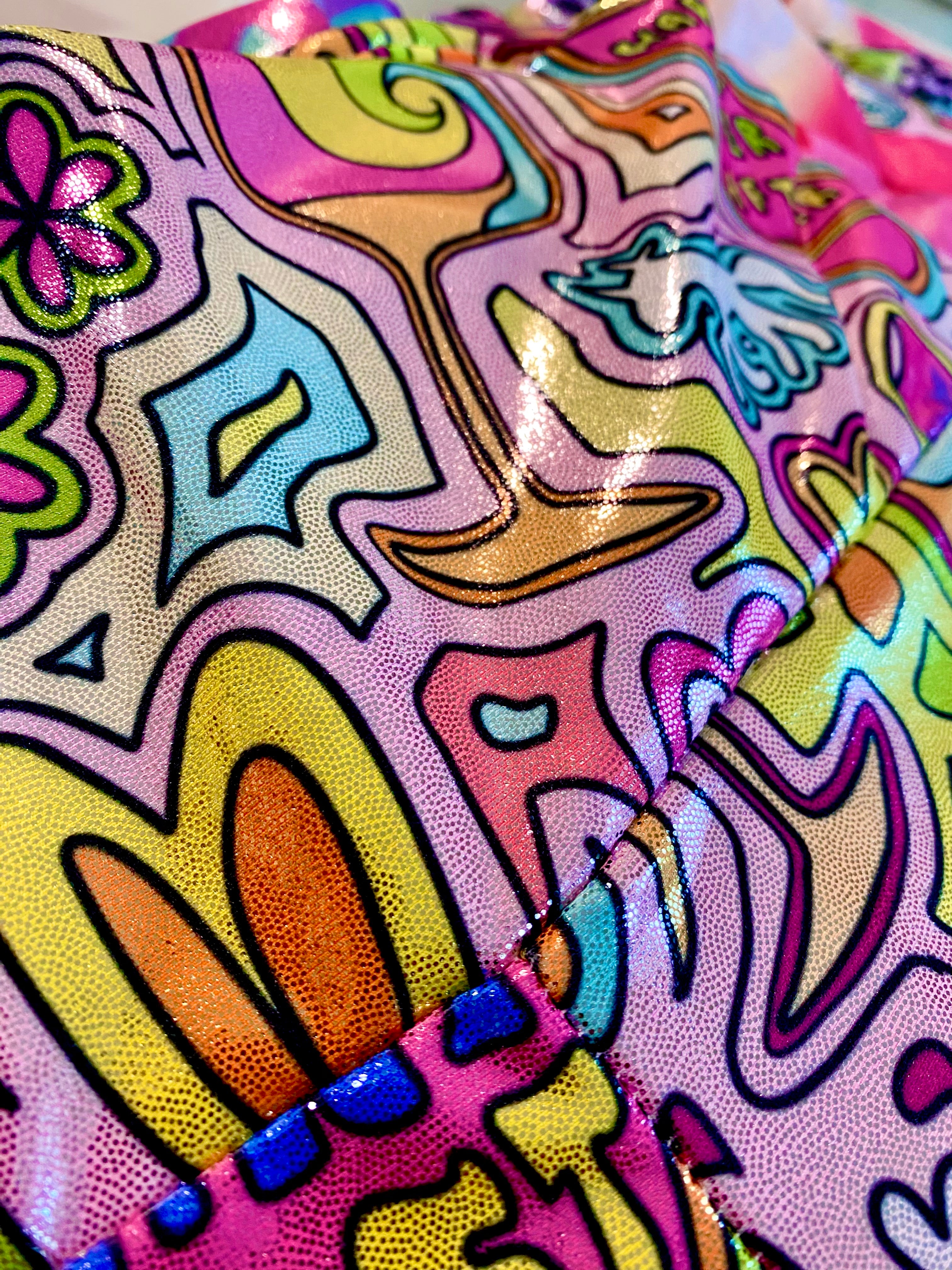 Colorful glitter shorts with whimsical unicorn patterns fabric close up view