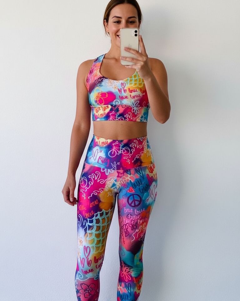 Person wearing a colorful sports bra and leggings matching set against a plain background