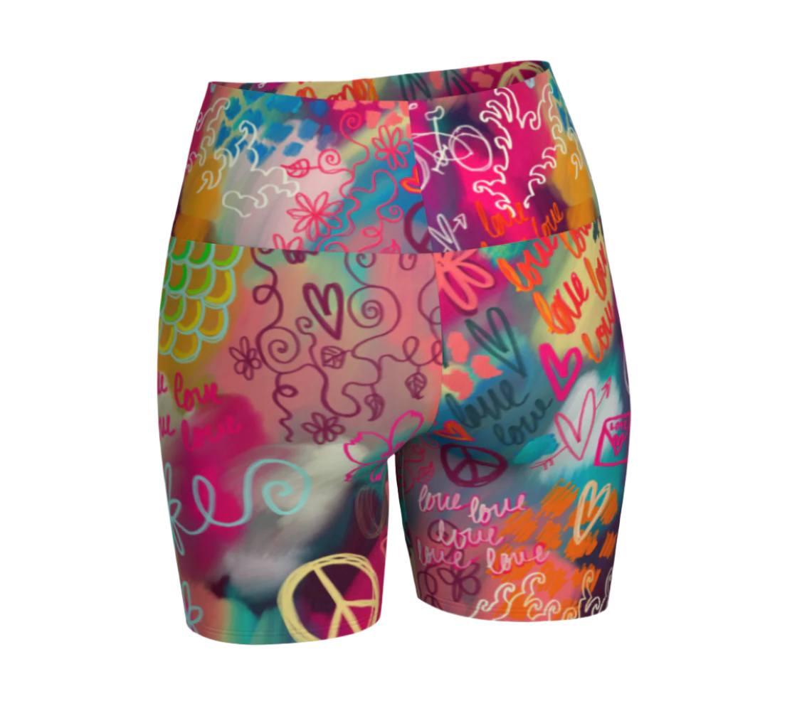 Colorful high-waisted yoga shorts with peace signs and heart designs on a white background