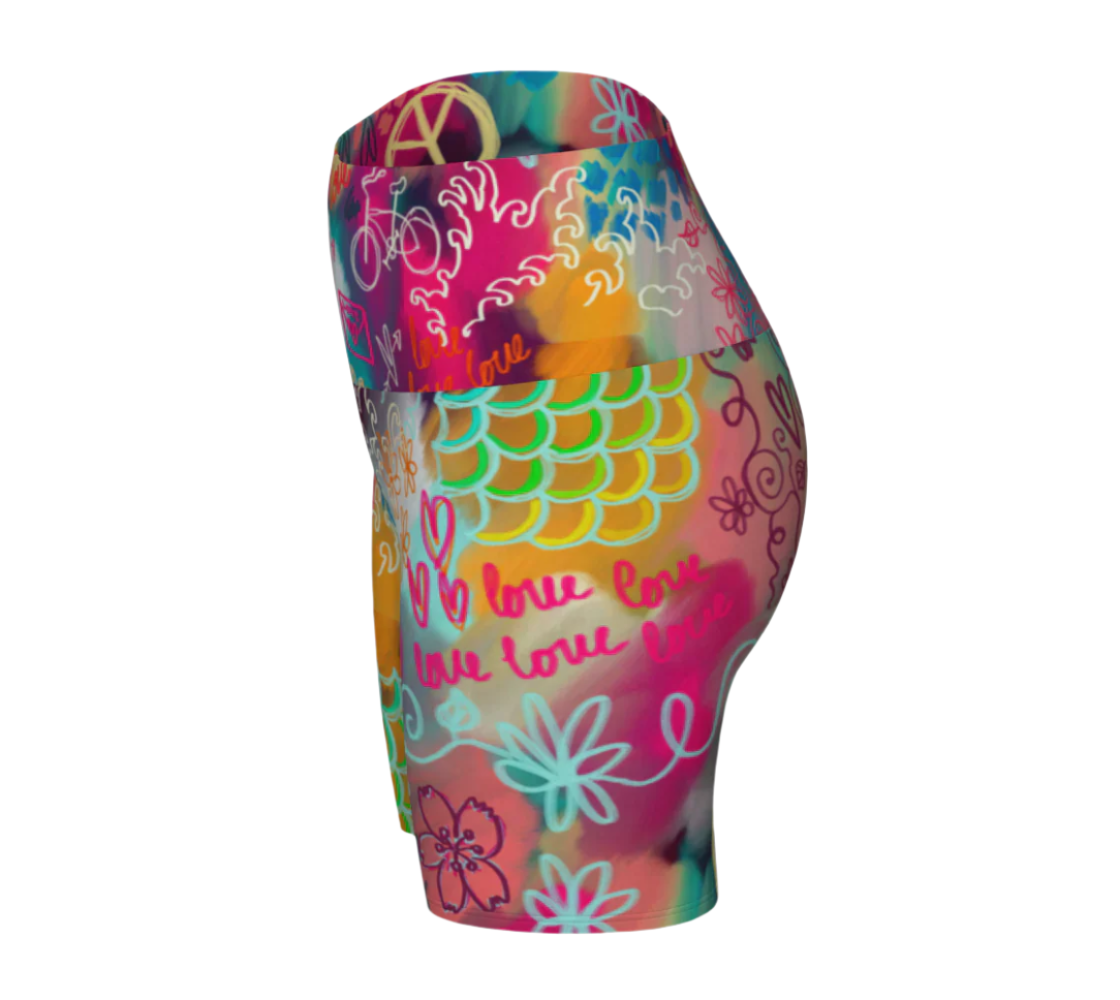 Colorful yoga shorts with floral and mermaid scales design on a white background