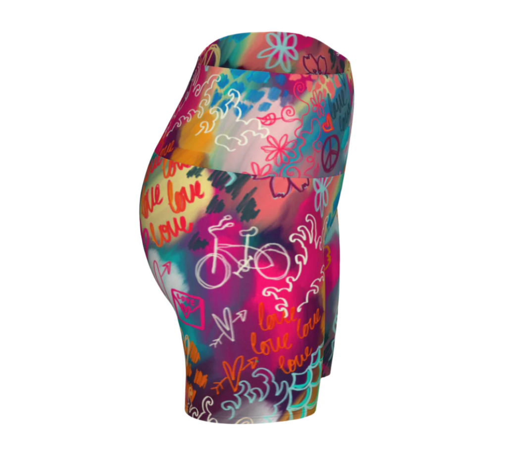 Colorful high-waisted yoga shorts with abstract patterns and text on a white background