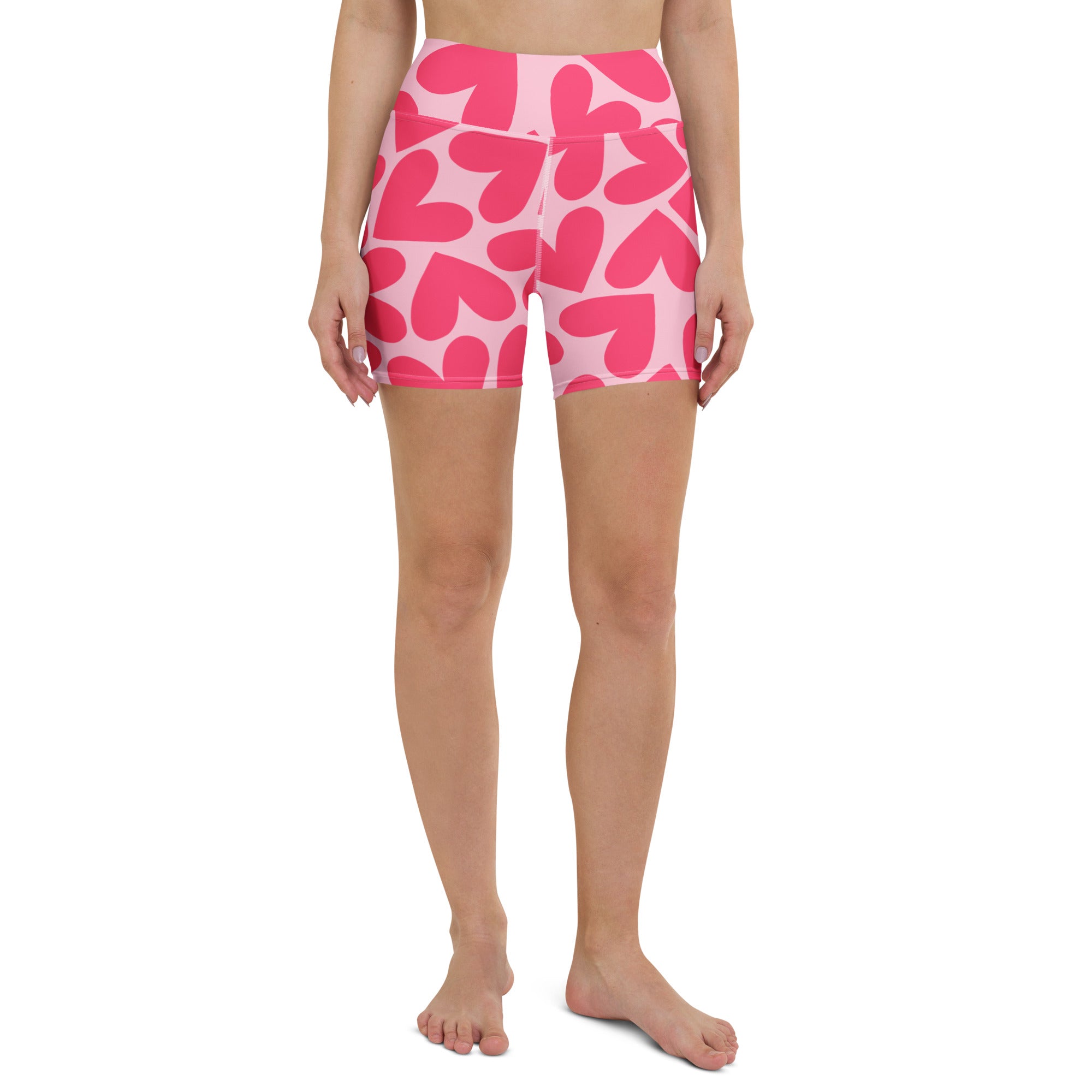 Woman wearing pink heart-patterned shorts on a white background