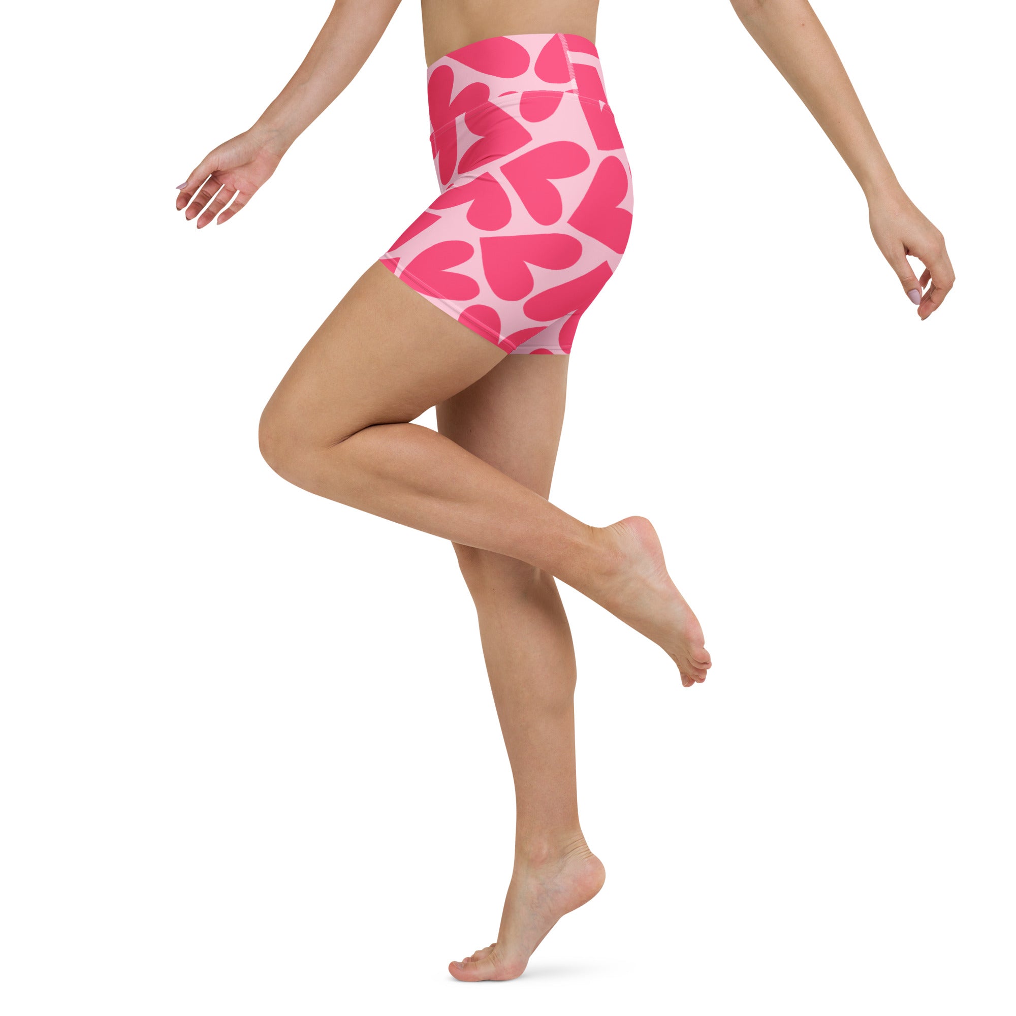 Woman wearing pink heart-patterned shorts on a white background