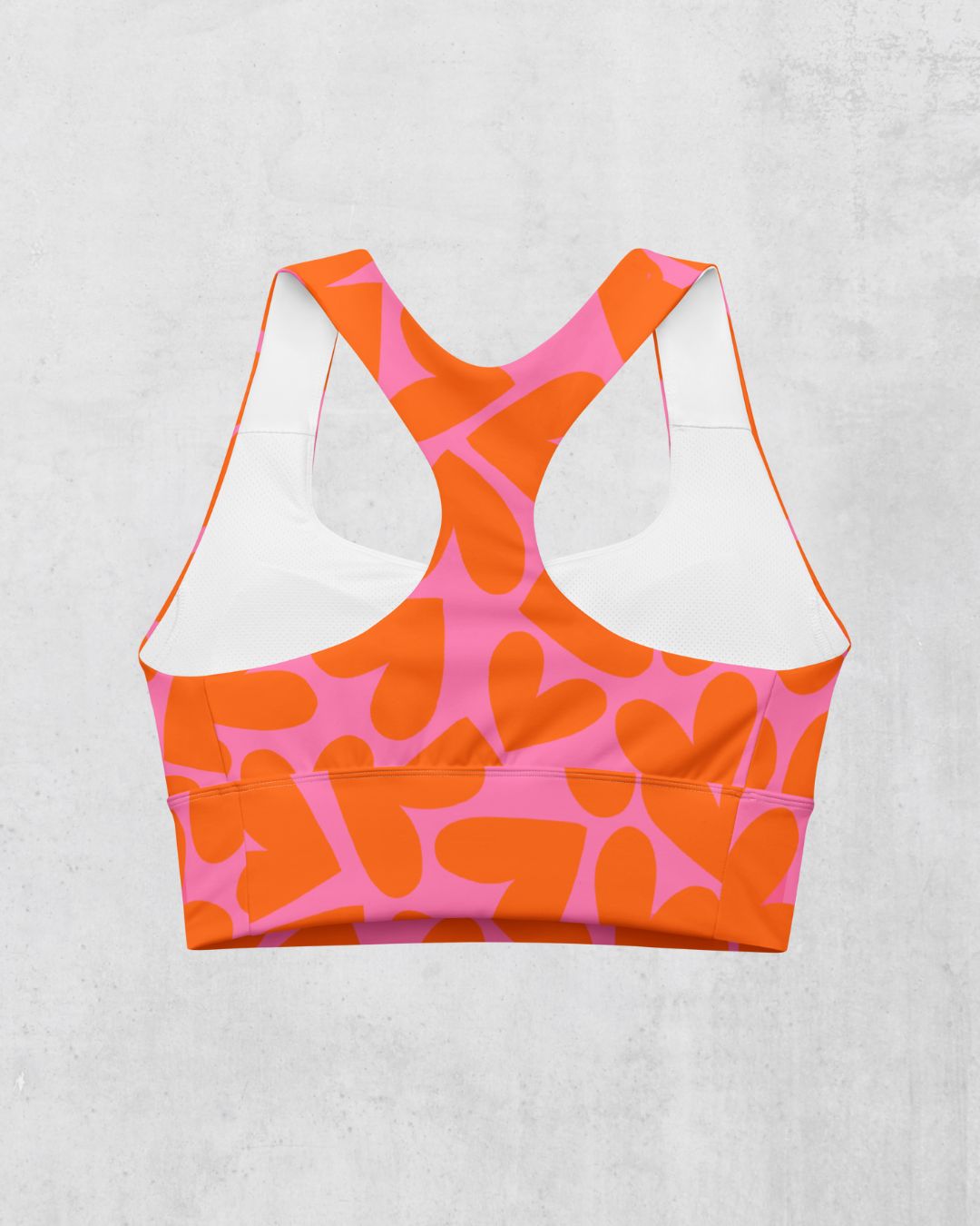 Orange and pink patterned sports bra on a light gray background, back side
