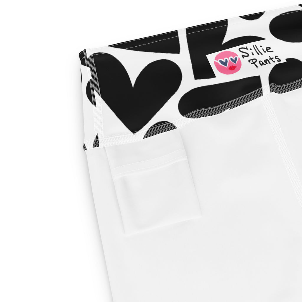 Yoga leggings with black and white hearts print and small back pocket at the waistband on a white background